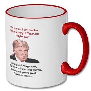 May include: White ceramic coffee mug with a red rim and handle. The mug features a black and white image of Donald Trump and text that reads "You are the Best Teacher in the history of Teachers. Maybe ever. Very special. Very smart. That I can tell you. Just terrific. Believe me, you're great. Everyone agrees."