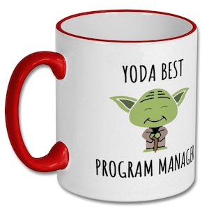 Peut inclure: Mug en c&eacute;ramique blanche avec une anse et un bord rouges. La tasse pr&eacute;sente une image de dessin anim&eacute; de Yoda avec le texte "YODA BEST PROGRAM MANAGER" en lettres noires. Un cadeau amusant.