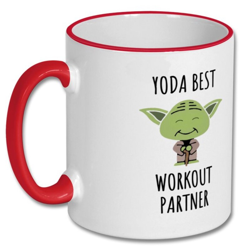 May include: White ceramic mug with a red rim and handle. The mug features a cartoon image of Yoda from Star Wars with the text "Yoda Best Workout Partner".