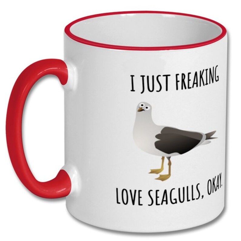 May include: White ceramic coffee mug with a red rim and handle. The mug features a cartoon seagull and the text "I just freaking love seagulls, okay!"
