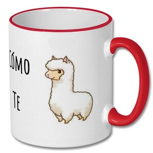 May include: White ceramic coffee mug with a red rim and handle. The mug features a cartoon alpaca with the text "C&oacute;mo te" printed on the front.
