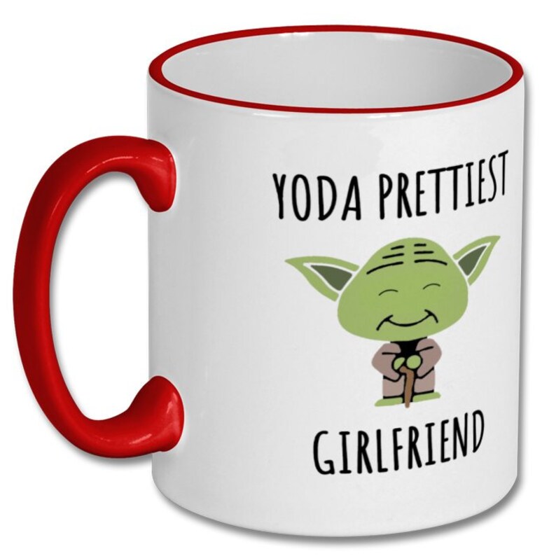 Puede incluir: Taza de cer&aacute;mica blanca con borde y asa rojos. La taza presenta una imagen de dibujos animados de Yoda con el texto "Yoda Prettiest Girlfriend".