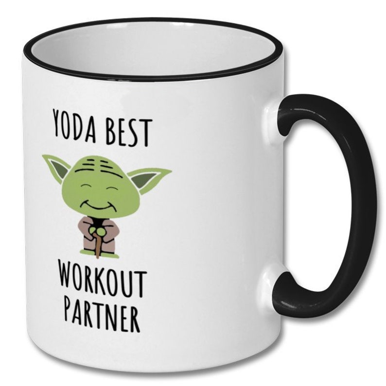 May include: White ceramic mug with a black rim and handle. The mug features a cartoon image of Yoda from Star Wars with the text "Yoda Best Workout Partner".