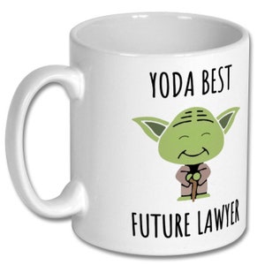 May include: White ceramic coffee mug with a green Yoda character illustration and the text "Yoda Best Future Lawyer".