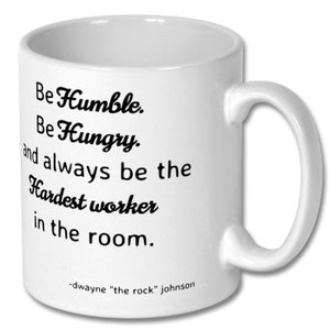 May include: White ceramic coffee mug with black text that reads "Be Humble. Be Hungry. and always be the Hardest worker in the room."  The text is attributed to "dwayne "the rock" johnson".
