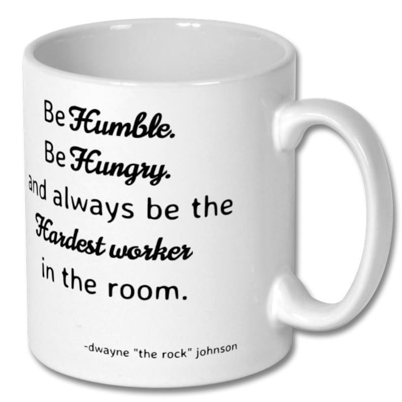May include: White ceramic coffee mug with black text that reads "Be Humble. Be Hungry. and always be the Hardest worker in the room."  The text is attributed to "dwayne "the rock" johnson".