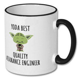 May include: White ceramic coffee mug with a black rim and handle. The mug features a cartoon image of Yoda with the text "Yoda Best Quality Assurance Engineer".