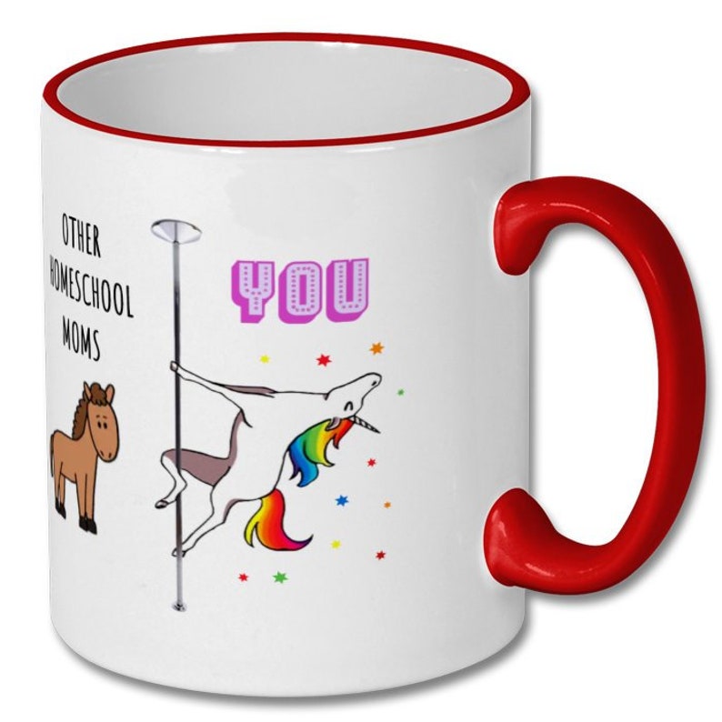 May include: White ceramic coffee mug with a red rim and handle. The mug features a cartoon unicorn with a rainbow tail and mane, holding onto a pole. The text "Other Homeschool Moms" and "You" are printed on the mug.