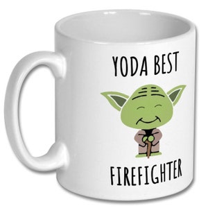 May include: White ceramic coffee mug with a green cartoon Yoda character holding a stick. The text "YODA BEST FIREFIGHTER" is printed on the mug.