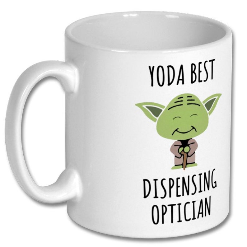 May include: White ceramic mug with a green Yoda character illustration and the text "Yoda Best Dispensing Optician".