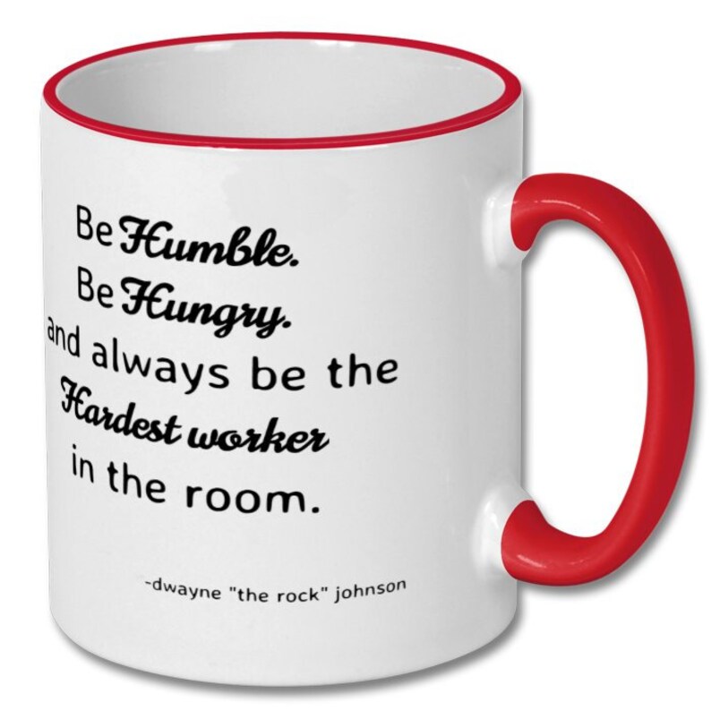 May include: White ceramic coffee mug with a red rim and handle. The mug features a motivational quote by Dwayne "The Rock" Johnson: "Be Humble. Be Hungry. And always be the Hardest worker in the room."
