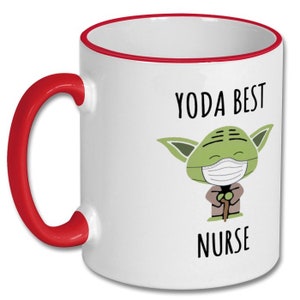 K&ouml;nnte beinhalten: Wei&szlig;e Keramiktasse mit rotem Rand und Henkel. Die Tasse zeigt ein Cartoon-Bild von Yoda, der eine Gesichtsmaske tr&auml;gt und einen Gehstock h&auml;lt. Der Text "YODA BEST NURSE" ist auf die Tasse gedruckt.
