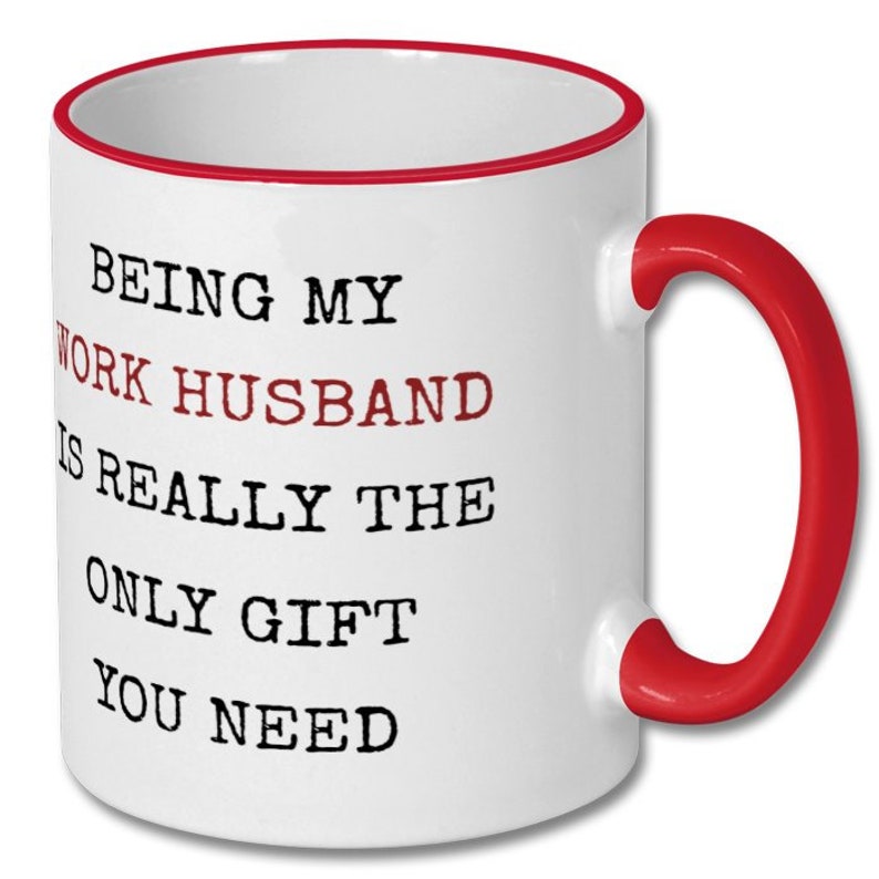 May include: White ceramic mug with a red interior, handle, and rim. The mug features the text "BEING MY WORK HUSBAND IS REALLY THE ONLY GIFT YOU NEED" in black and maroon lettering.