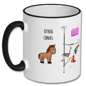 May include: White coffee mug with a black rim and handle. The mug has a cartoon image of a unicorn on a pole dancing and a brown horse on the left side. The text "OTHER CRNAS" is above the horse and "ME" is above the unicorn.