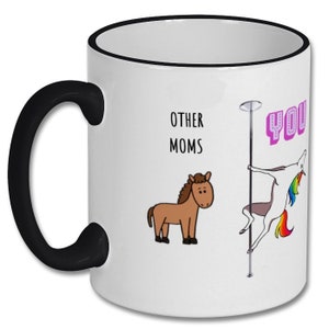 May include: White coffee mug with a black rim and handle. The mug has a cartoon image of a horse and a unicorn on a pole. The text "Other Moms" and "You" are printed on the mug.
