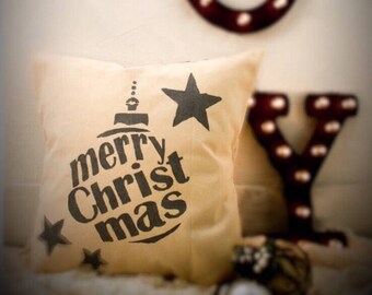 Może przedstawiać: Beżowa poduszka z czarno-białym wzorem choinkowej ozdoby z napisem "merry Christ mas" i dwoma gwiazdami.