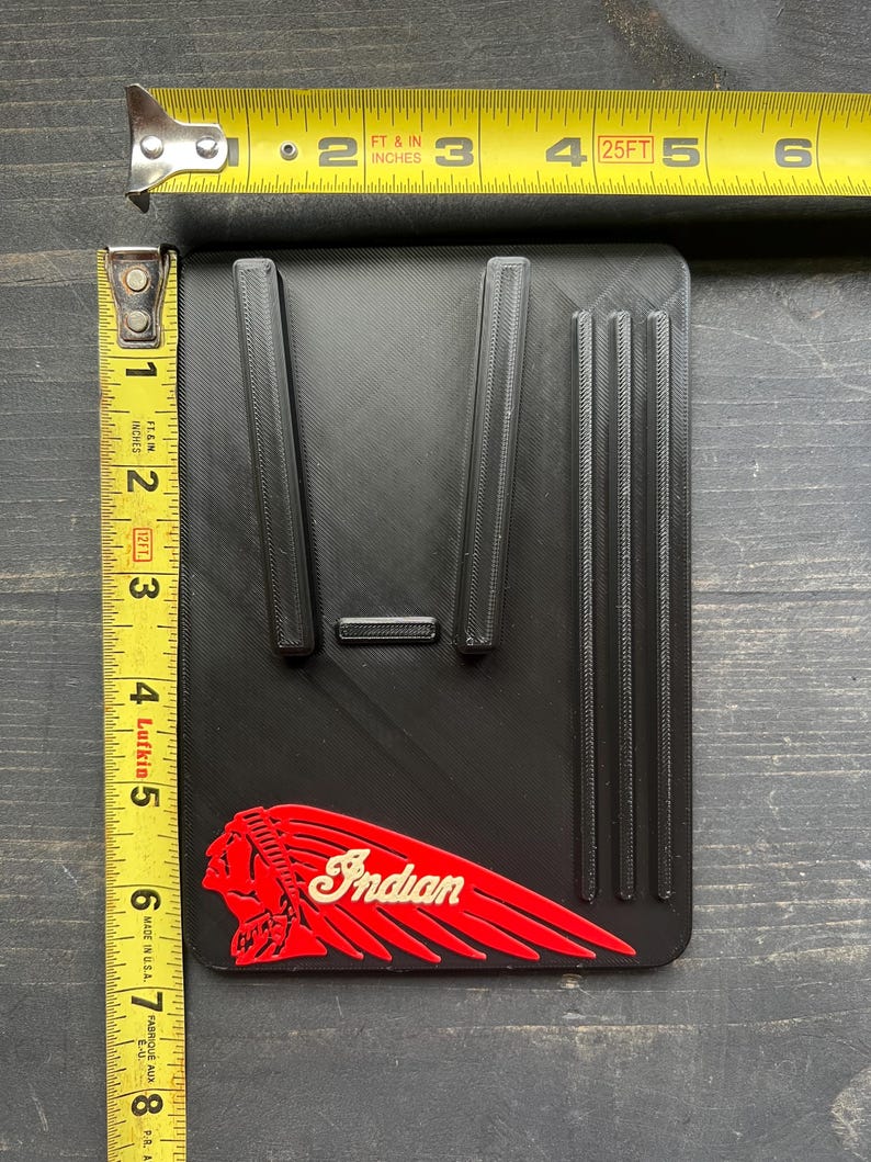 Puede incluir: Art&iacute;culo rectangular negro con crestas elevadas y el logotipo "Indian" rojo y blanco. El art&iacute;culo mide aproximadamente 12,7 cm de largo y 7,6 cm de ancho. Una cinta m&eacute;trica amarilla est&aacute; en el fondo.
