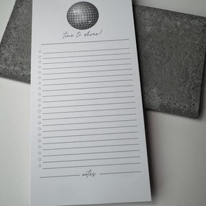 May include: A white notepad with a black disco ball graphic and the text "time to shine!"  The notepad has a lined section for writing and a blank section at the bottom labeled "notes".