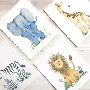 Pu&ograve; includere: Quattro acquerelli di animali: un elefante blu, una giraffa marrone, una zebra in bianco e nero e un leone marrone. Ogni animale &egrave; raffigurato in uno stile semplice e fantasioso ed &egrave; circondato da erba verde e fiori.