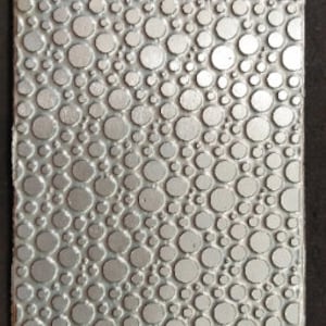 May include: A silver textured sheet with a repeating pattern of raised circles.