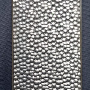 May include: A rectangular silver-toned metal plate featuring a raised, repeating honeycomb or bubble-like texture across its entire surface. The metallic finish creates a reflective appearance with distinct shadows within the rounded indentations.