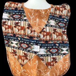 May include: A brown and blue patterned vest with a moose design and the text "Welcome to the Lodge".