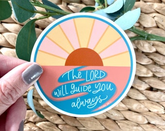 Puede incluir: Una pegatina redonda con un diseño de amanecer colorido y el texto "The Lord will guide you always - Isaiah 58:11".