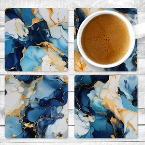 May include: Set of four blue, white, and gold abstract coasters with a marbleized design. The coasters are square and feature a swirling pattern of blue, white, and gold.