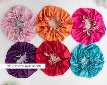 Könnte beinhalten: Sechs Hauben aus Satin in Hellrosa, Orange, Pink, Lila, Rot und Türkis, jeweils mit gerafftem Gummizug und kontrastierendem Innenfutter. Der Text 26 Colors Available ist auf einem weißen rechteckigen Overlay aufgedruckt.