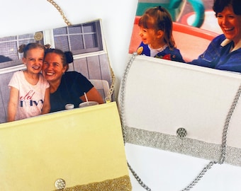 May include: Two rectangular clutch purses with chain straps. One purse is shiny gold with a photo of two people on the flap. The other is shiny silver with a photo of two people on the flap. Both feature a magnetic snap closure.
