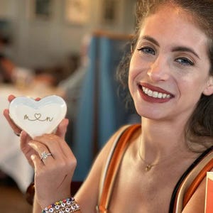 a woman is holding a heart shaped box