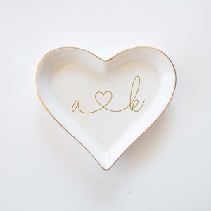 a heart shaped dish with the word a and k on it