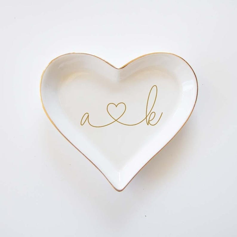 a heart shaped dish with the word a and k on it