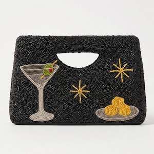 K&ouml;nnte beinhalten: Schwarze, perlenbesetzte Clutch mit Henkel, mit einem Martiniglas mit Olive, Sternen und einem Teller mit Vorspeisen. Die Clutch hat eine rechteckige Form mit einem ausgeschnittenen Henkel.