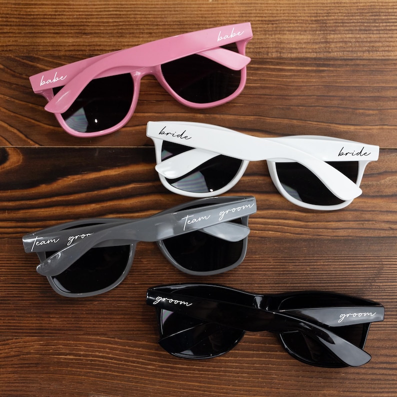 three pairs of sunglasses sitting on top of a wooden table