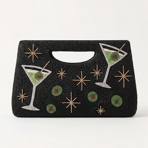 K&ouml;nnte beinhalten: Schwarze, perlenbesetzte Handtasche mit Martini-Gl&auml;sern und Sternenmustern. Die Martini-Gl&auml;ser sind gr&uuml;n mit roten Oliven-Akzenten. Die Tasche hat einen Griff und ist mit goldenen und wei&szlig;en Perlen verziert.