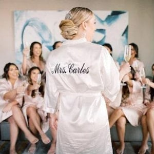 a woman in a robe standing in front of a group of women