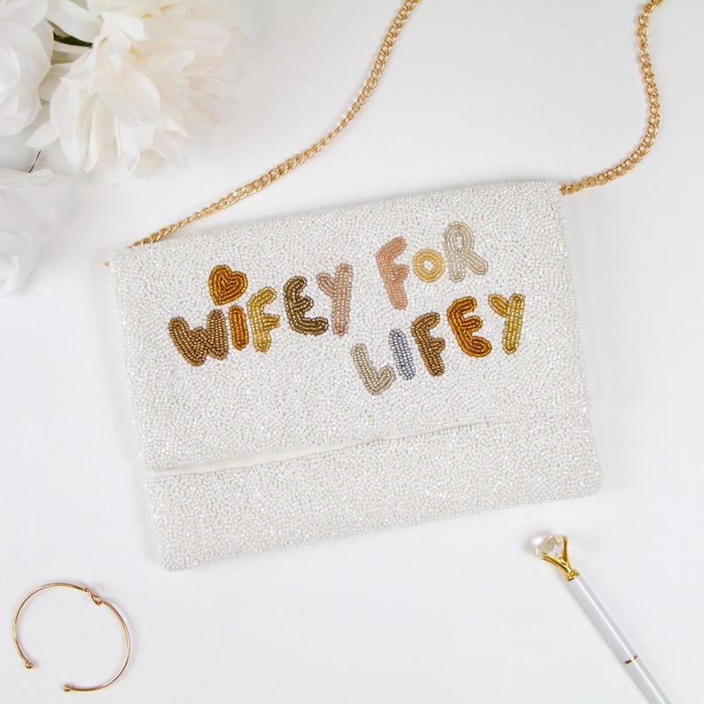 a white purse sitting on top of a white table