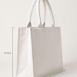 A large white tote bag with measurements provided.