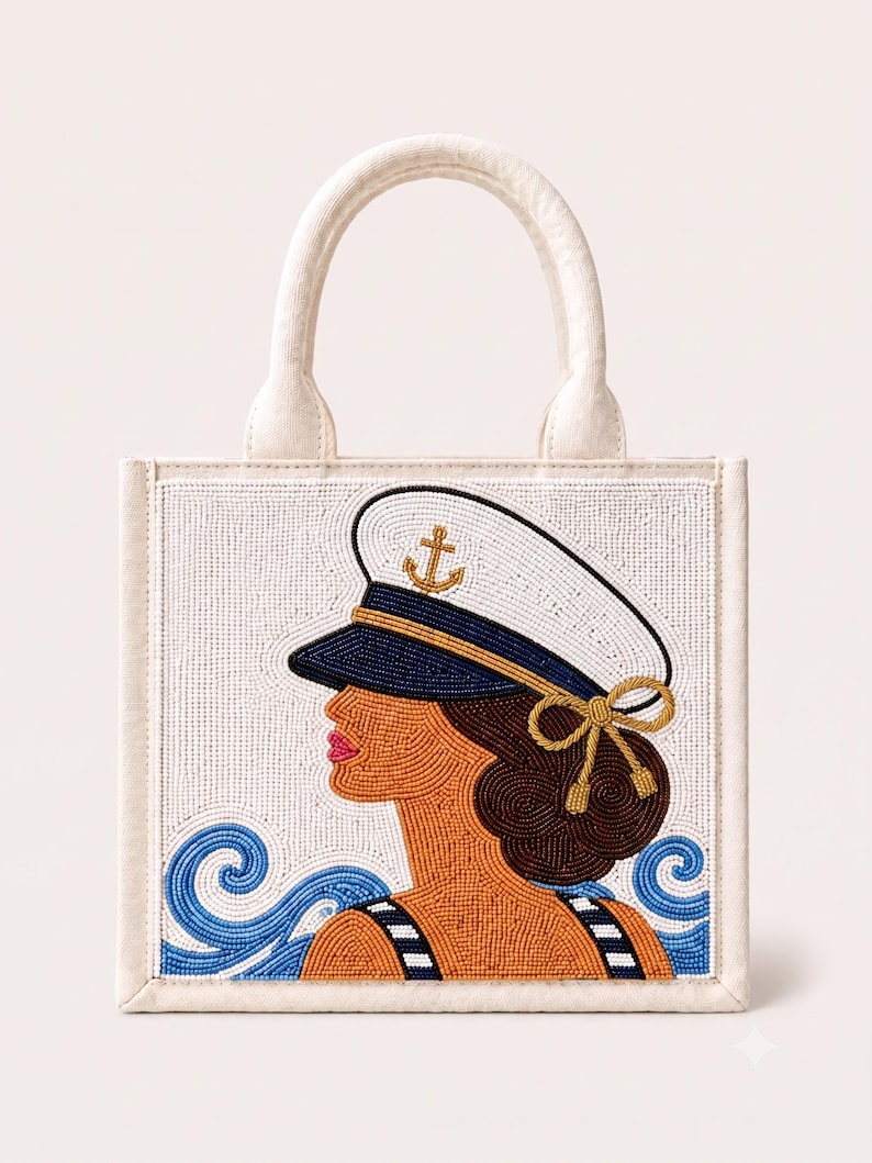 May include: A square off-white tote bag featuring a beaded design of a person wearing a white and navy blue captain's hat with a gold anchor emblem. The design includes brown hair, a striped top, and blue beaded waves on a white background.