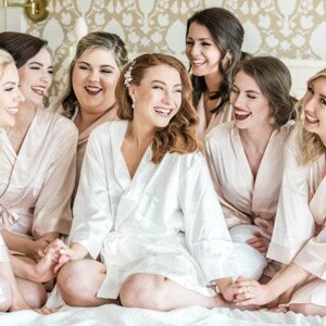 a group of women sitting on top of a bed
