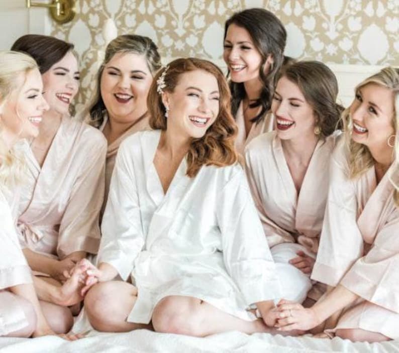 a group of women sitting on top of a bed