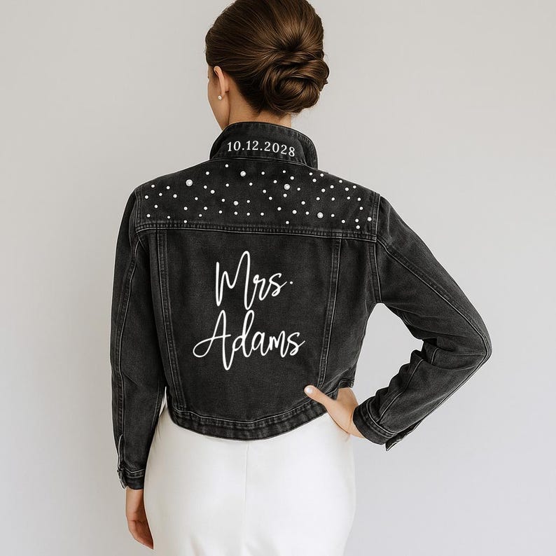 A woman wearing a black denim jacket with white polka dots and the text "Mrs. Adams" printed on the back.