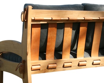 Sofá Quilpo de 3 plazas, hecho a mano. Estructura de madera noble. Respaldo con correas de cuero. Tapizado de calidad.