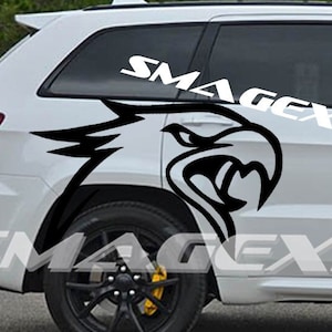 May include: White SUV with black wheels and yellow brake calipers. A large black and white eagle graphic is on the side. The text "SMAGEXITY DESIGNZ" is displayed on the side of the vehicle.