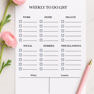 May include: A white weekly to-do list with sections for work, home, health, social, hobbies, and miscellaneous tasks. A pink pen and pink flowers are on the side. The list includes space for wins and losses.