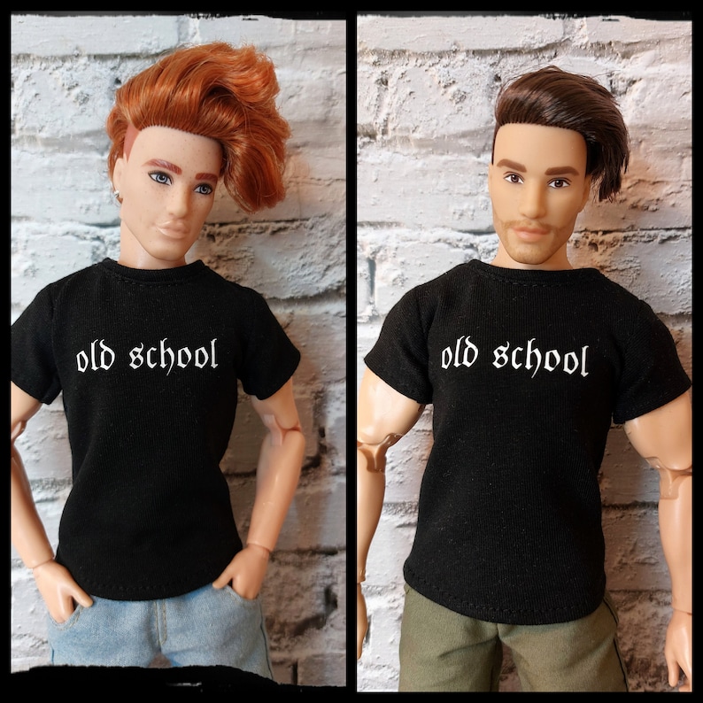 May include: Two dolls wearing black t-shirts with the text "old school" printed in white. The dolls have different hairstyles and are standing in front of a white brick wall.