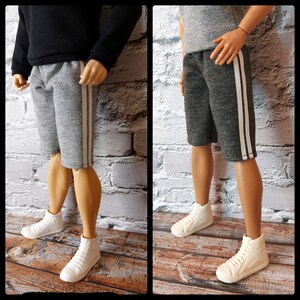 Może przedstawiać: Szare szorty z białymi paskami po bokach. Szorty wykonane są z miękkiej, wygodnej tkaniny i mają luźny krój.