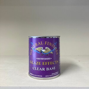 May include: A purple can of General Finishes Glaze Effects Clear Base water-based paint. The can features a gold eagle logo and the text "CAUTION: MAY CAUSE EYE IRRITATION. CAREFULLY READ ALL CAUTIONARY LABELS."