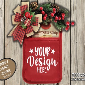 May include: Red oven mitt with a white "YOUR DESIGN HERE" text and a Christmas-themed bow with red and black plaid ribbon. The oven mitt is on a wood background.